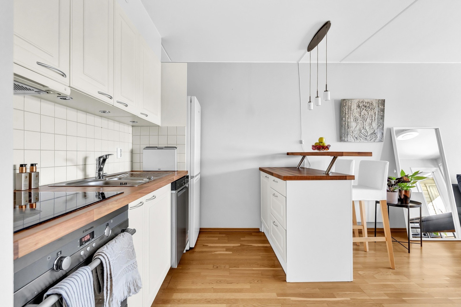 Lys kjøkkeninnredning fra 2007 med profilerte fronter og benkeplater av laminat. Galleribilde