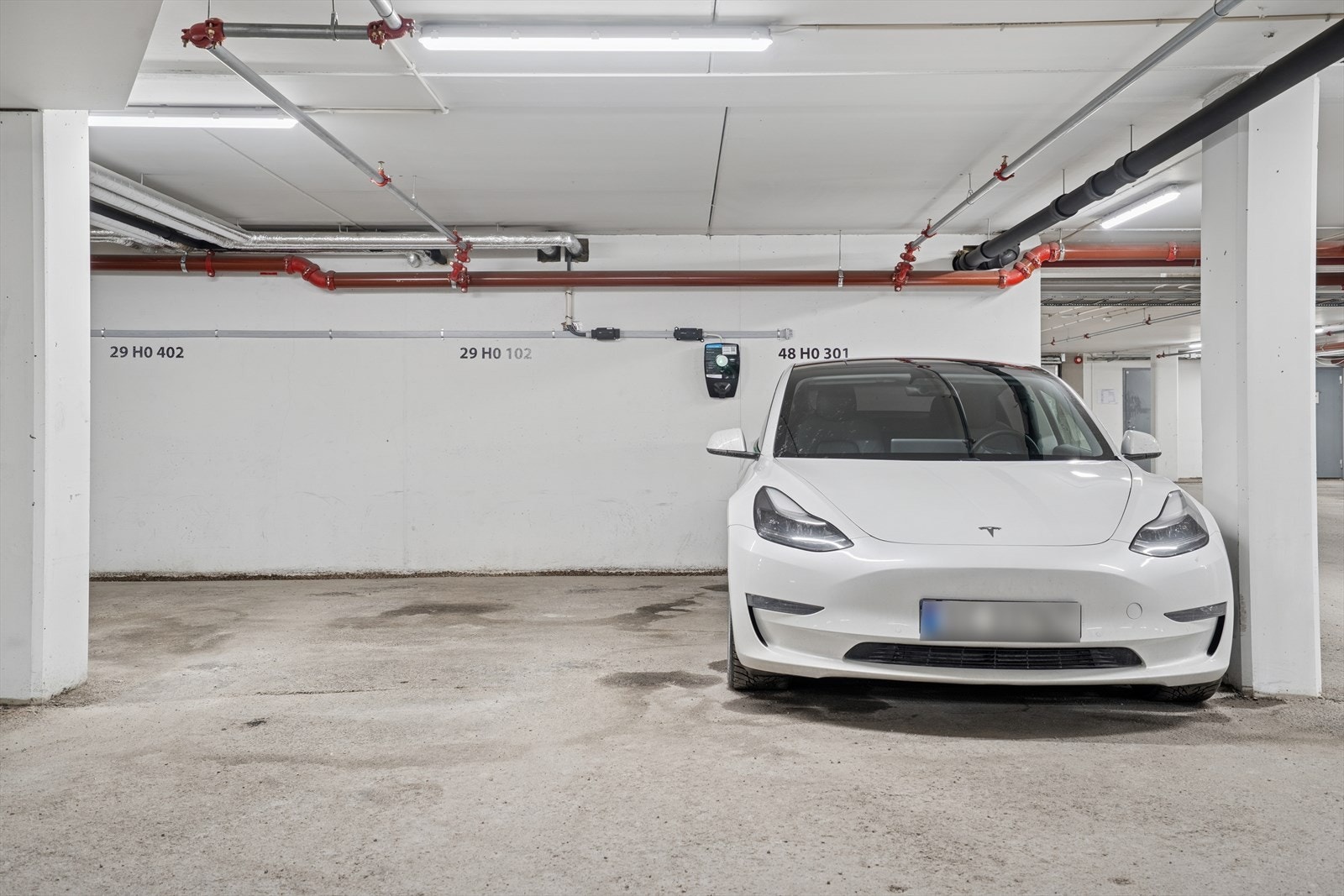 Parkeringsplass med elbillader i felles garasjeanlegg Galleribilde