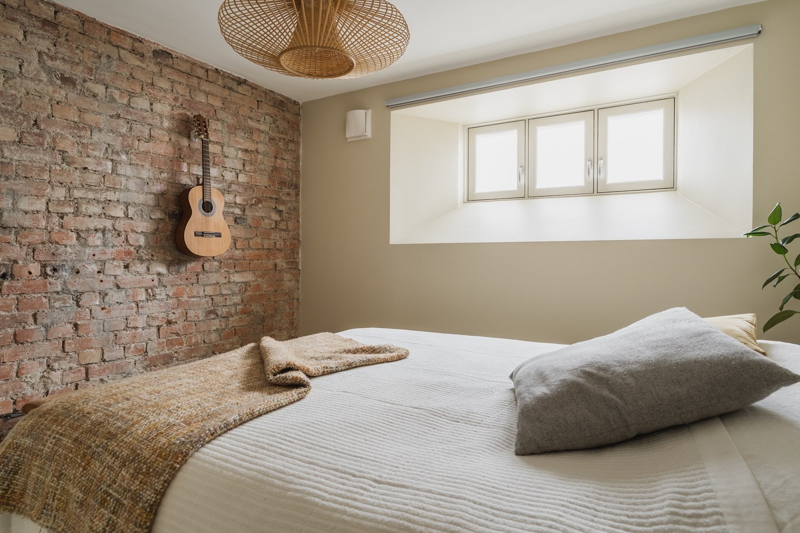 Romslig soverom med lekker teglsteinsvegg Galleribilde