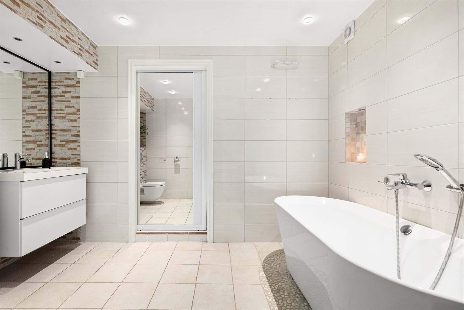 Pent flislagt bad med varmekabler i gulv og downlights i himling. Galleribilde