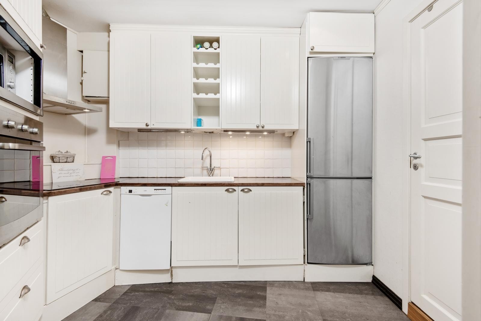 Kjøkken med oppvaskmaskin, kombiskap, vaskemaskin og komfyr. Galleribilde