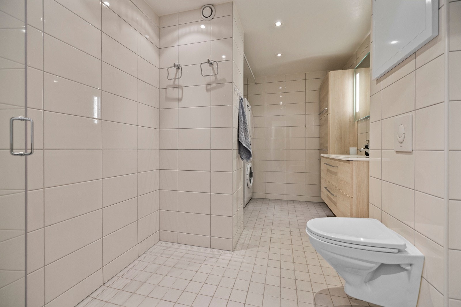 Badet har flislagte overflater og downlights som sørger for godt lys, og gulvet er oppvarmet med varmekabler Galleribilde