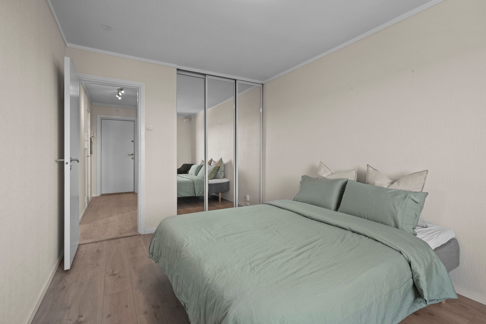 Rommet har en stor skyvedørsgarderobe med speilfronter, og gulv i laminat Galleribilde