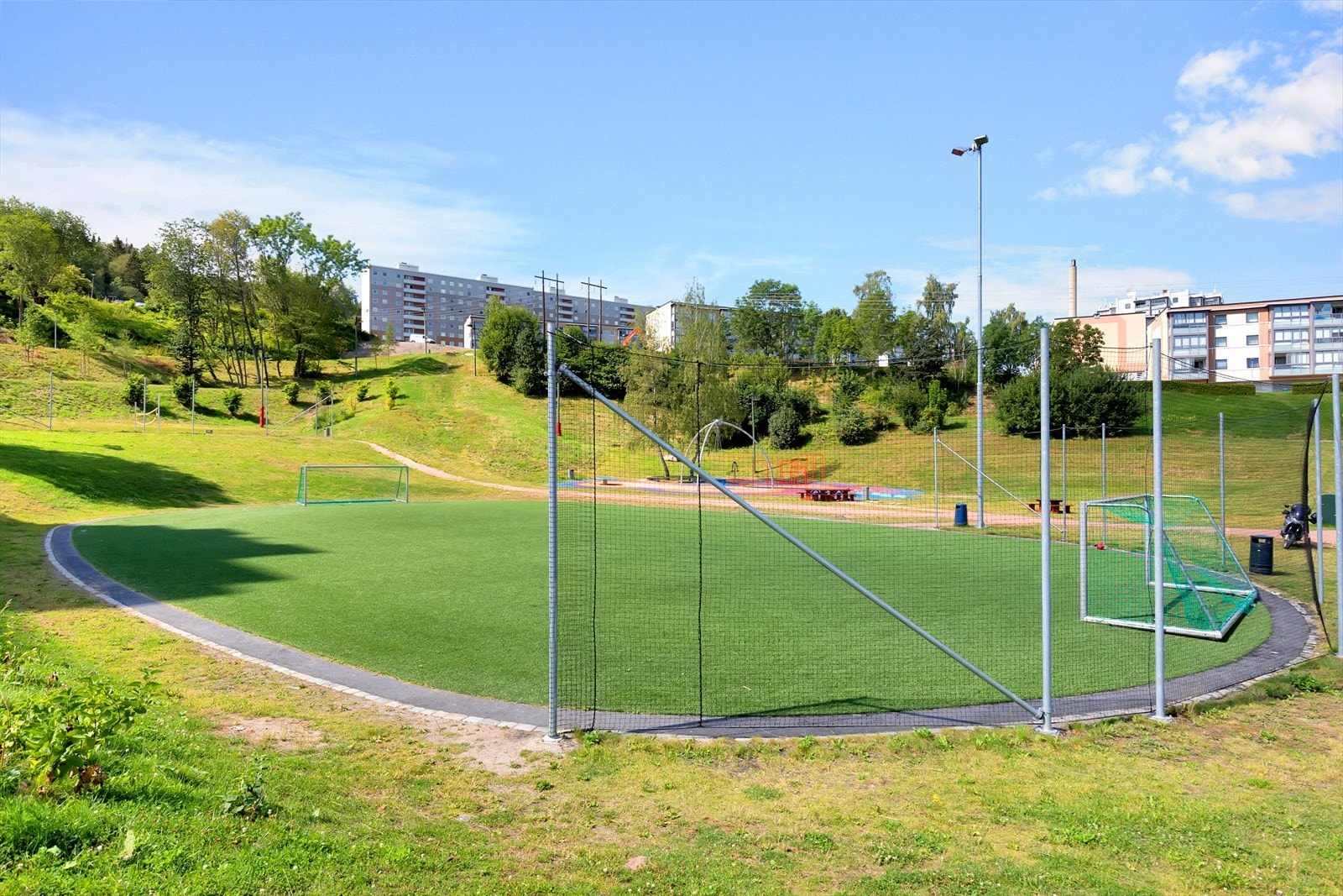 Dumpa aktivitetspark med kunstgressbane, sandvolleyballbane samt flott akebakke på vinterstid Galleribilde