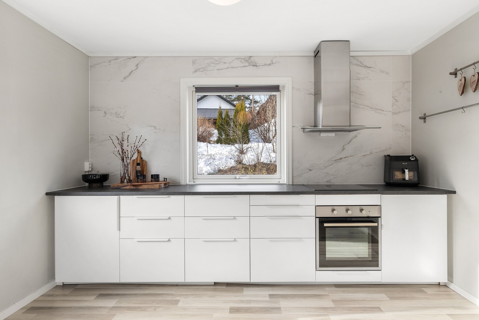 Stilrent kjøkken fra 2022 med integrert komfyr, induksjonstopp og vaskemaskin Galleribilde