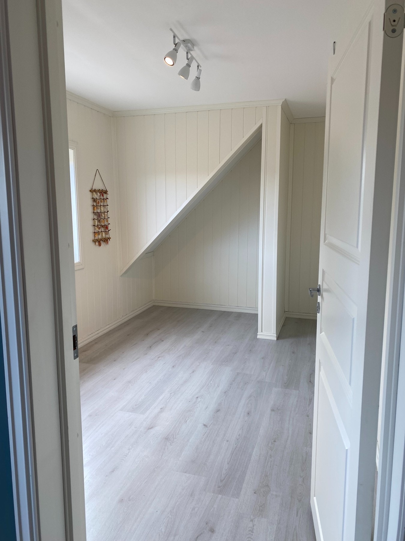 Rommet fører videre inn til soverom to med 1-stavs laminatgulv Galleribilde