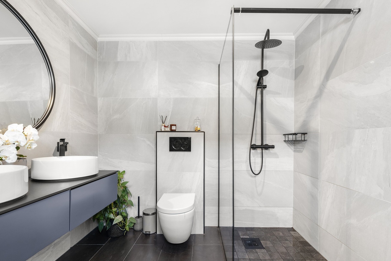 Badet består av servant med underskap, vegghengt klosett og dusjhjørne med regndusj Galleribilde