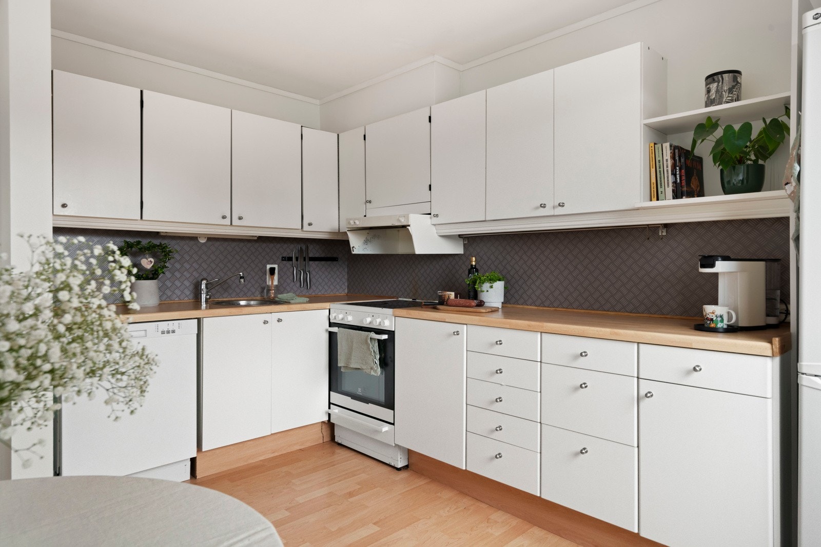 Kjøkkeninnredningen er utført med glatte fronter og benkeplate av laminat, og det er avsatt plass til kjøl-/fryseskap og komfyr. Videre er det opplegg for oppvaskmaskin og avtrekk via sentralt avtrekksanlegg i bygget. Galleribilde