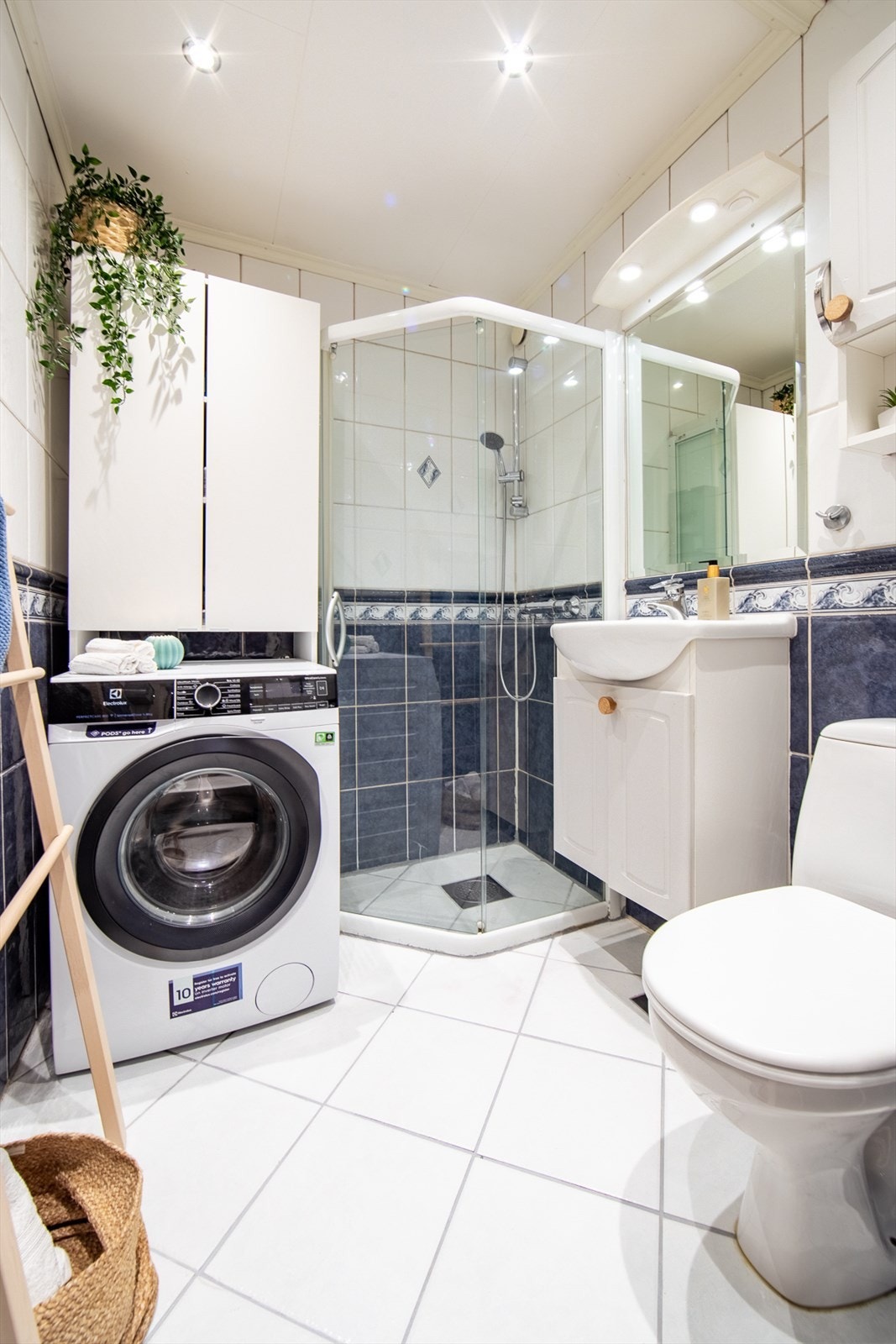 Badet er innredet med klosett, servant med innredning, innfelt speil og dusjhjørne med skyvbarglassdør. Det er opplegg for vaskemaskin og naturlig avtrekk. Galleribilde