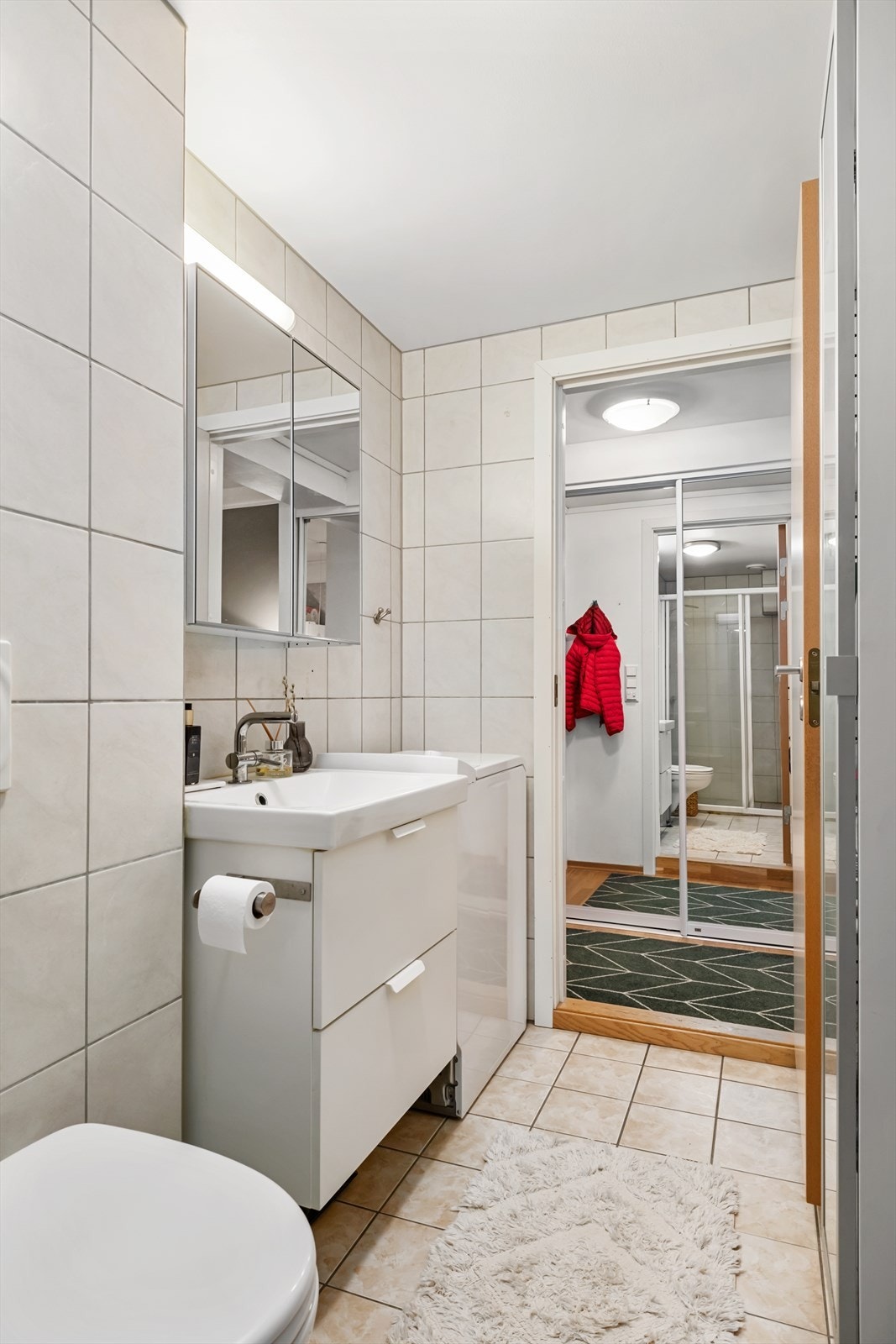 Innreiing består av dusjhjørne med dusjvegg, vegghengt toalett, baderomsmøbel med heildekkande servant og opplegg for vaskemaskin. Galleribilde