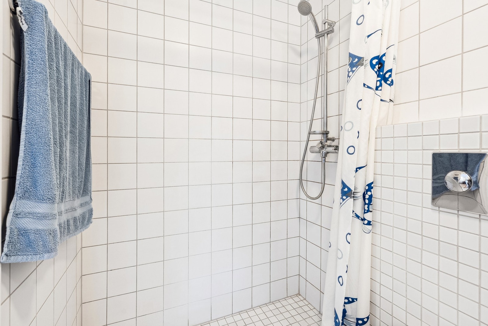 Rommet har servant, veggmontert toalett og dusjhjørne. Galleribilde