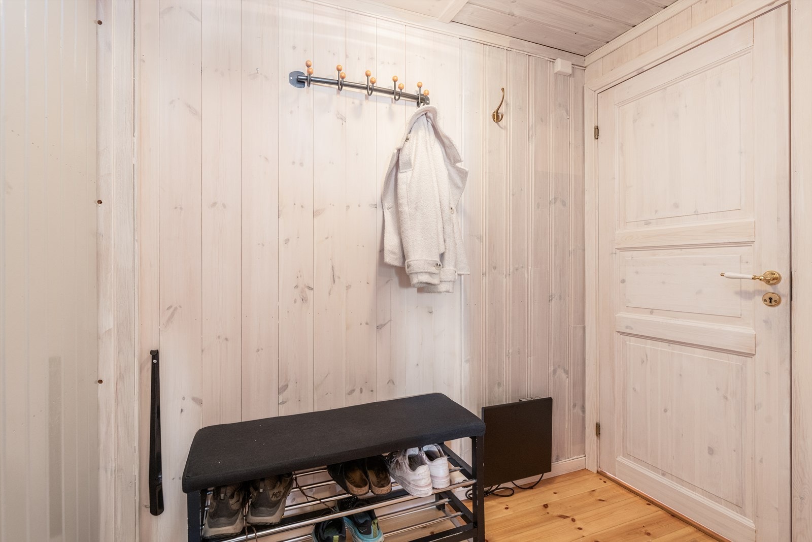 Trivelig entre som ønsker velkommen inn i hytta, hvor det er plass til sko og yttertøy. Galleribilde