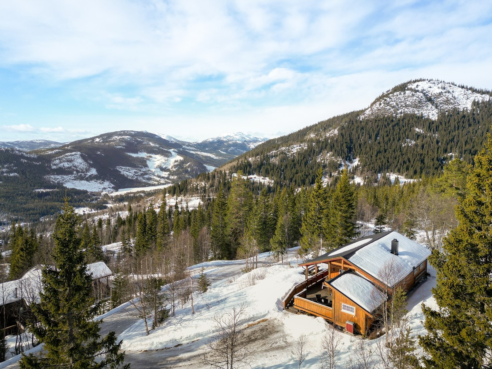Hytta har en stor terrasse på 33 m2 med nydelig utsikt mot Lifjell m.m. Et deilig sted å nyte dagene i fred og ro, med flotte turområder rett utenfor døren. Det er bilvei helt frem og parkering like utenfor hytta. Galleribilde