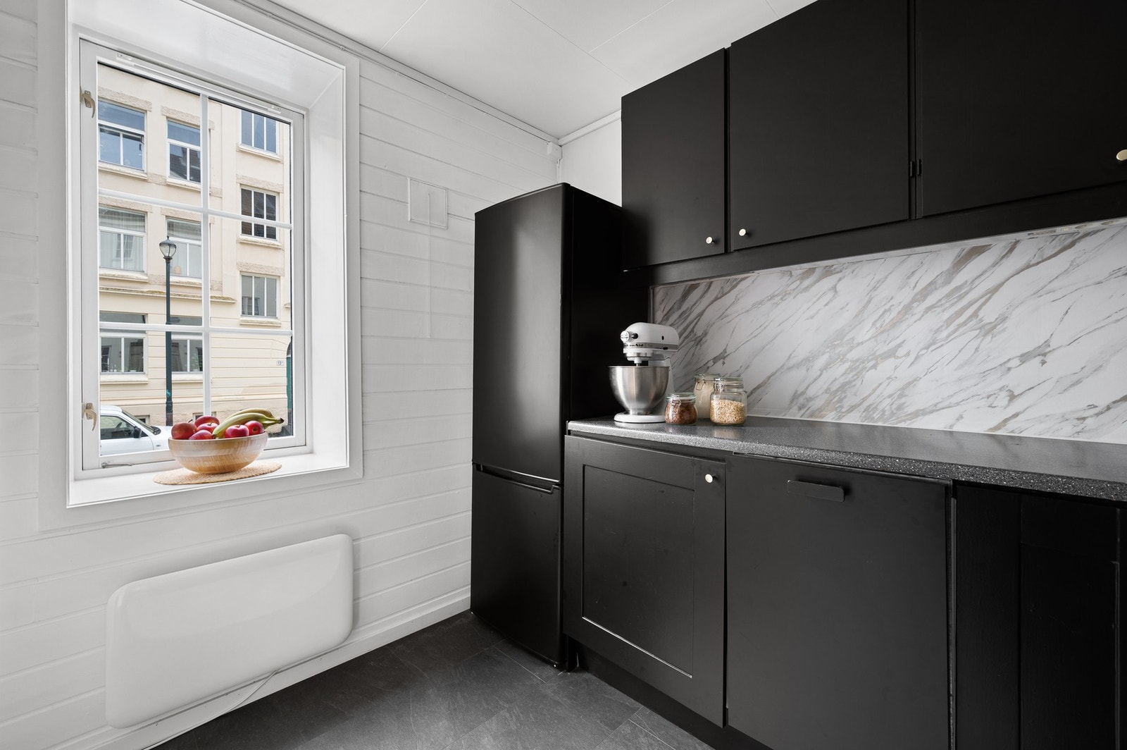 Kjøkkenet har innredning med glatte fronter og profilerte fronter. Benkeplaten er av laminat. Galleribilde