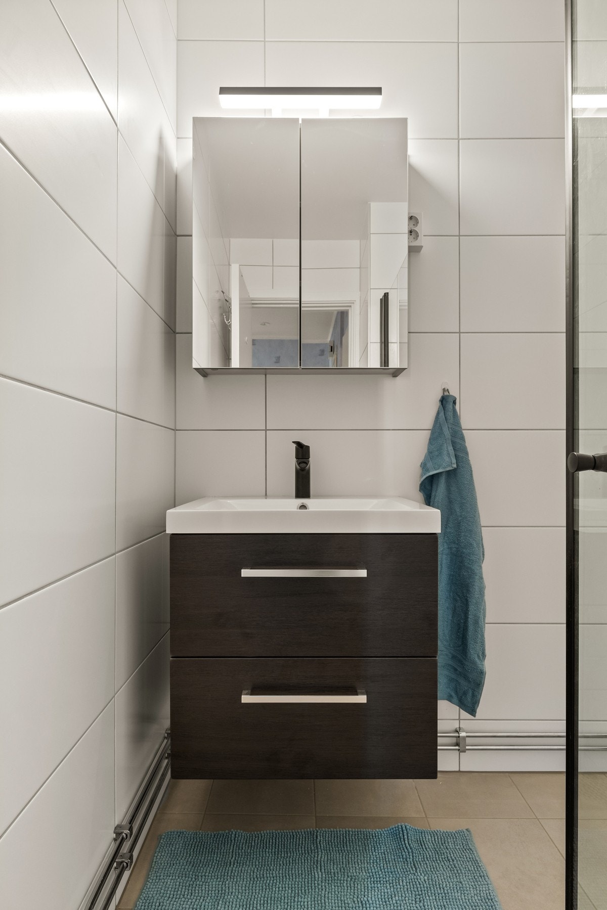 Bad er utstyrt med mørk innredning med servant og speil. Galleribilde