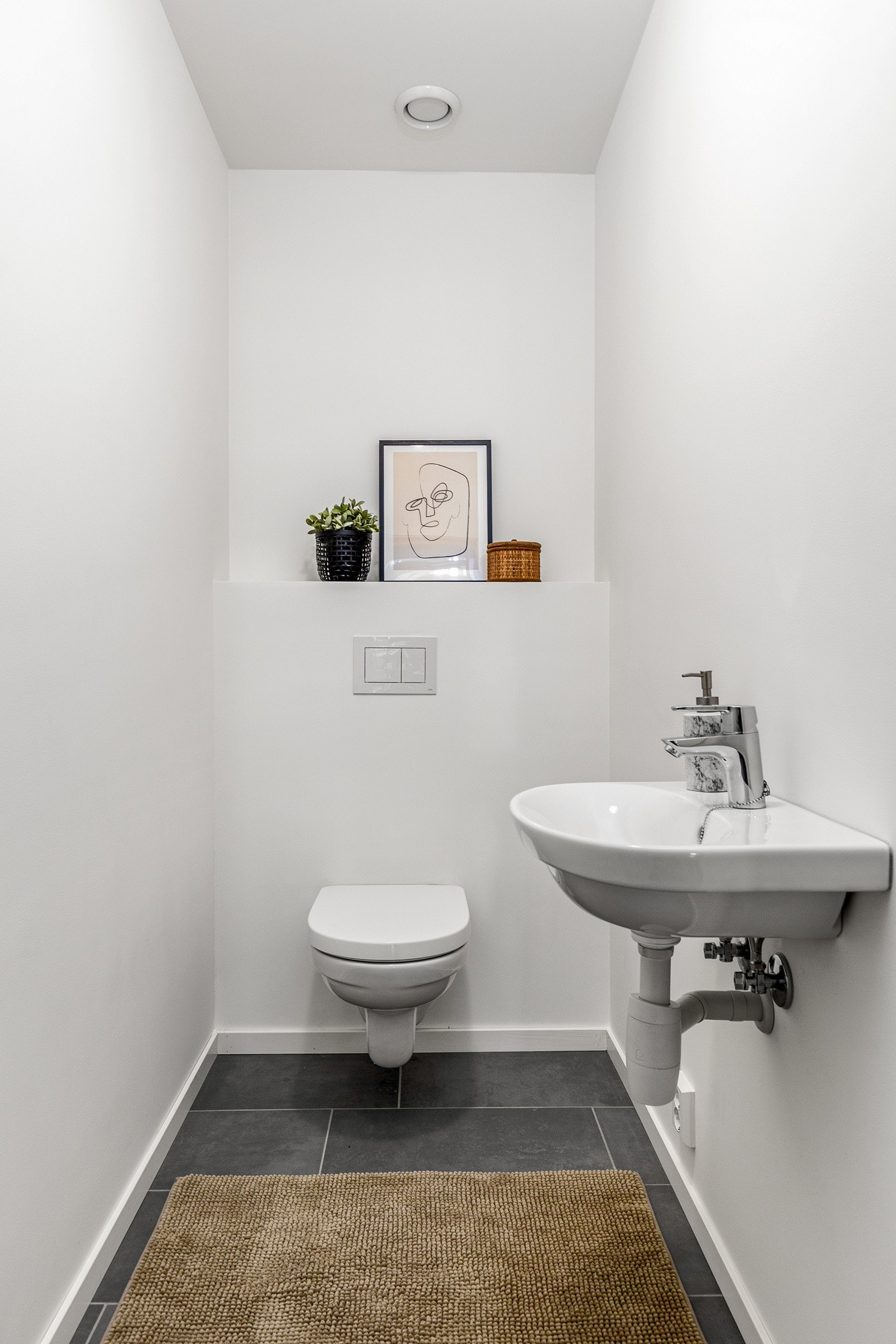 I første etasje ligger et praktisk gjestetoalett med fliser, toalett og servant. Det er avtrekk via balanserte ventilasjon. Galleribilde