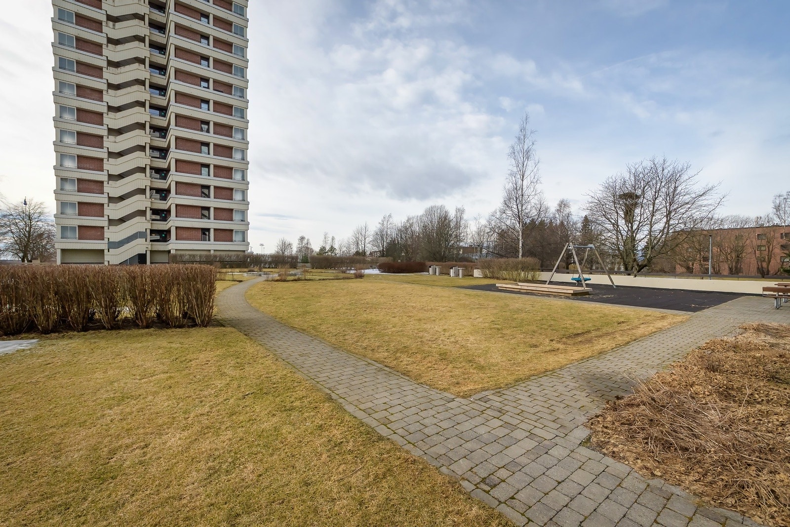 Pene fellesområder med plen, busker og sittegrupper. Galleribilde