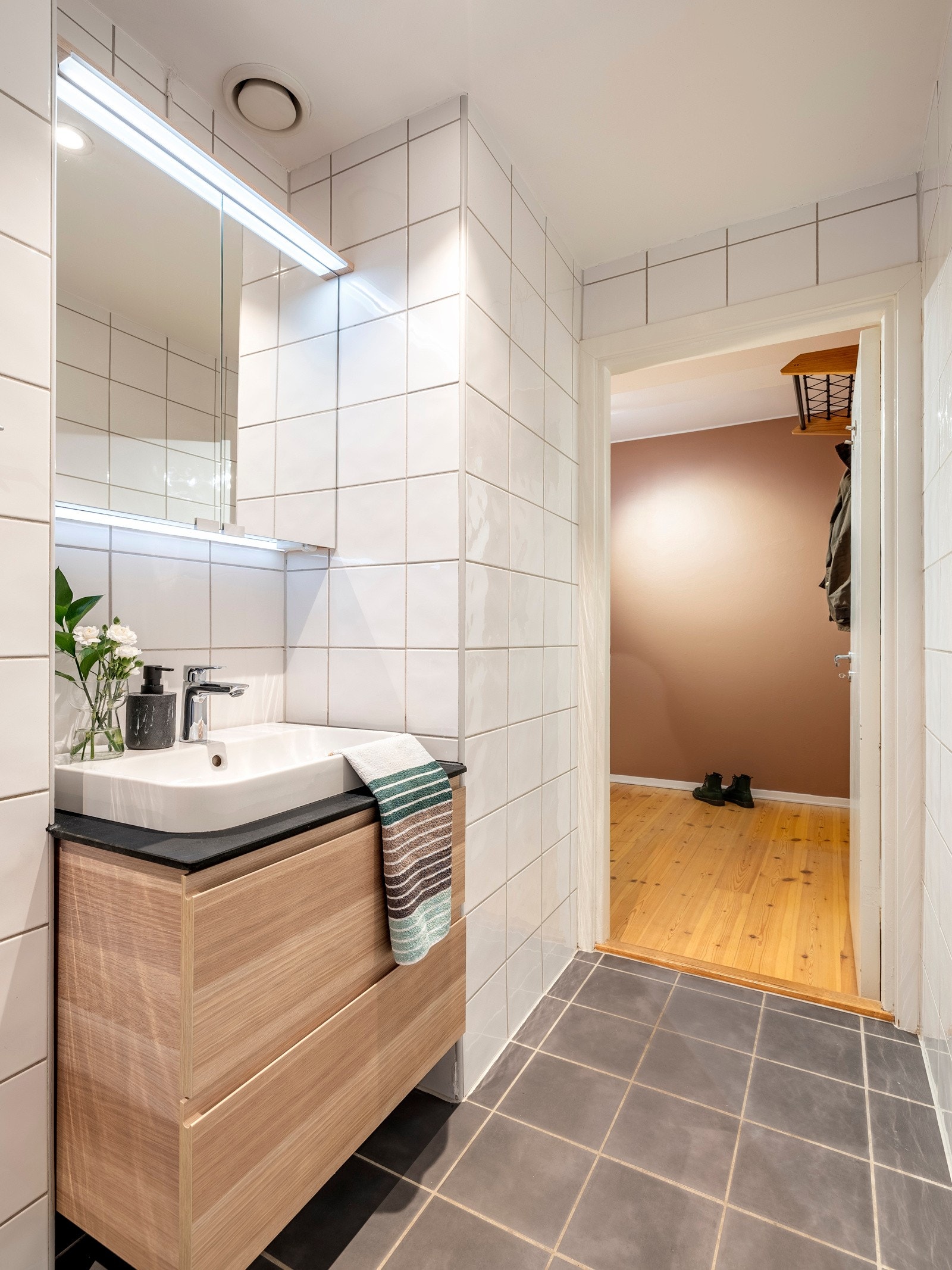 Baderomsinnredningen består av servantinnredning, speil på i overskap på vegg over toalett, toalett og dusjhjørne med skyvedør i frosset glass. Det er også opplegg for vaskemaskin. Galleribilde