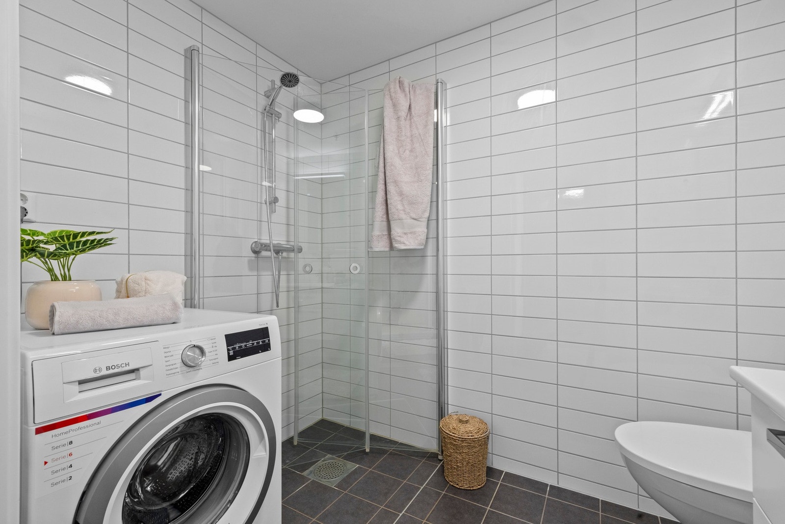 Delikat og pent flislagt bad med varme i gulv og opplegg for vaskemaskin. Galleribilde