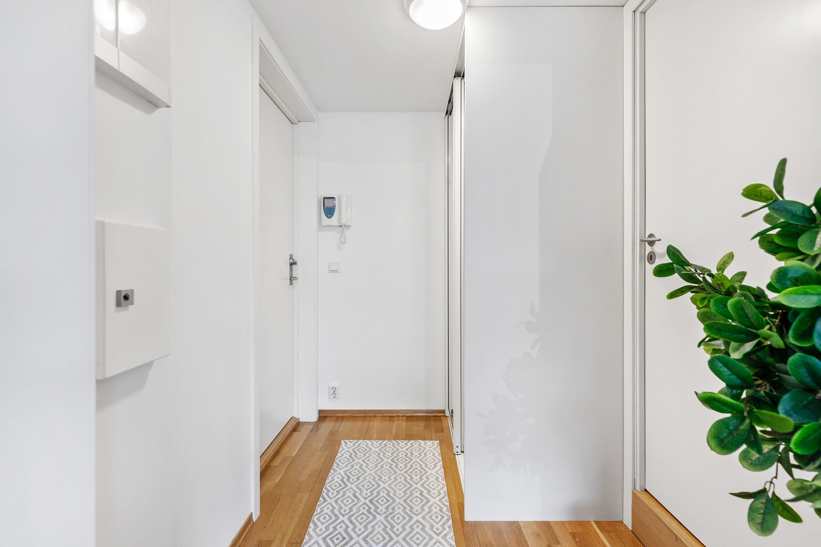 Entré med callinganlegg og skyvedørsgarderobe med speilfronter Galleribilde