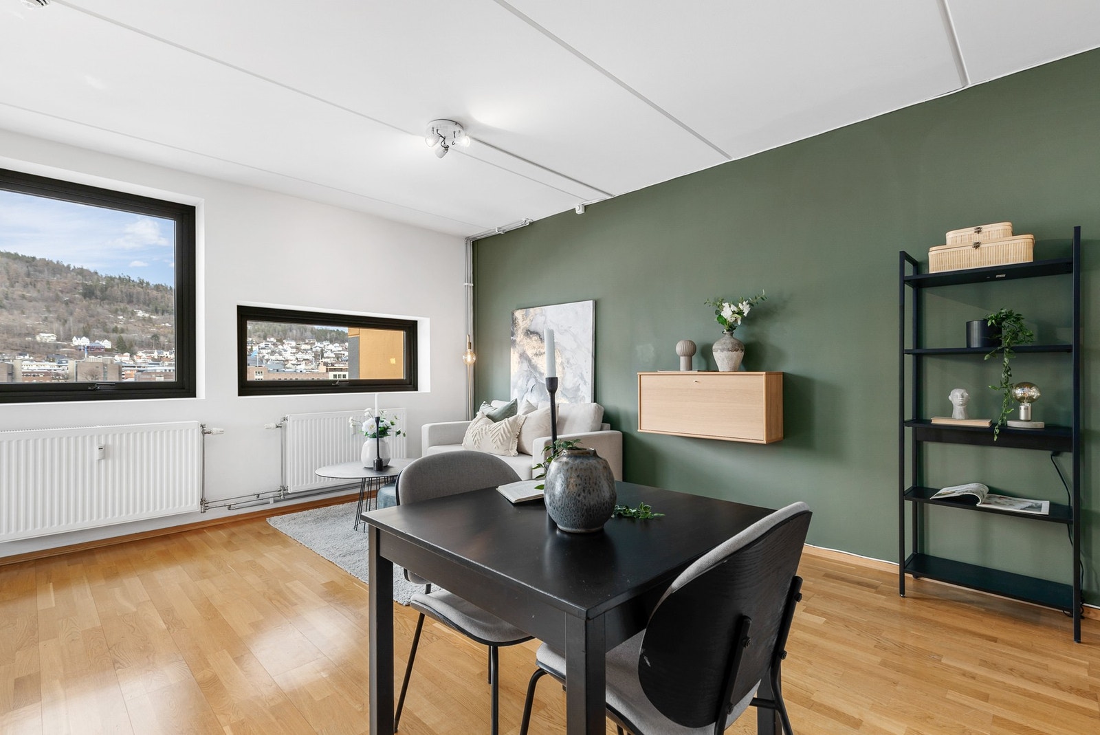 Stuen har plass til sofa og et spisebord, noe som skaper en hyggelig og funksjonell oppholdsplass Galleribilde