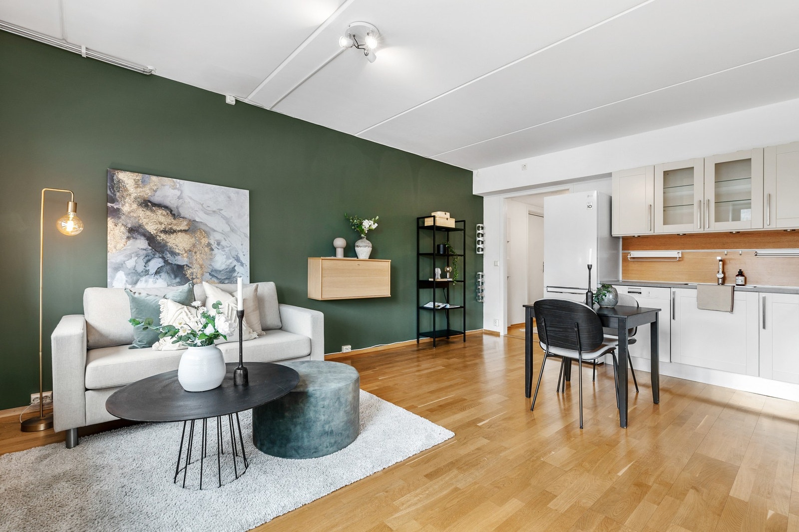 Rommet har parkettgulv og slette flater på vegger og himling, samt en kontrastvegg i mørk grønn farge Galleribilde