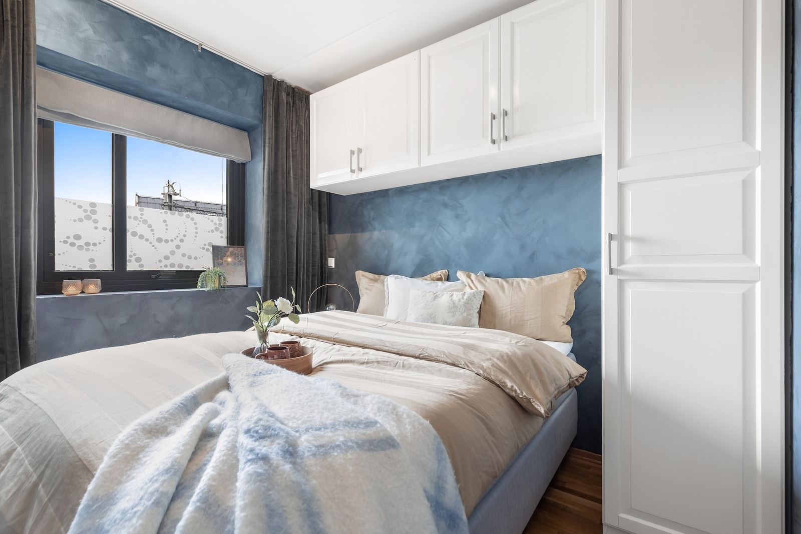 Smarte oppbevaringsløsninger i form av skap, både på siden og over sengen, sørger for effektiv utnyttelse av plassen Galleribilde