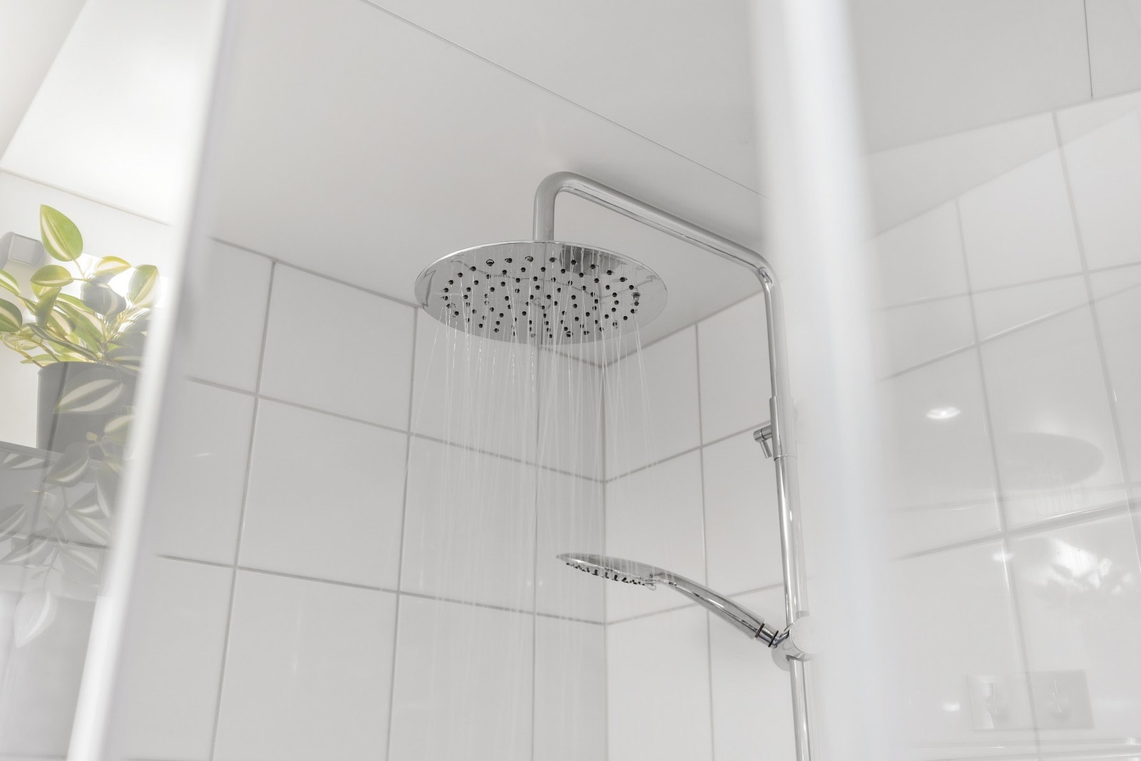 Videre inneholder badet et dusjhjørne med innfellbare dører og et vegghengt dusjarmatur med både hånddusj og regndusj Galleribilde