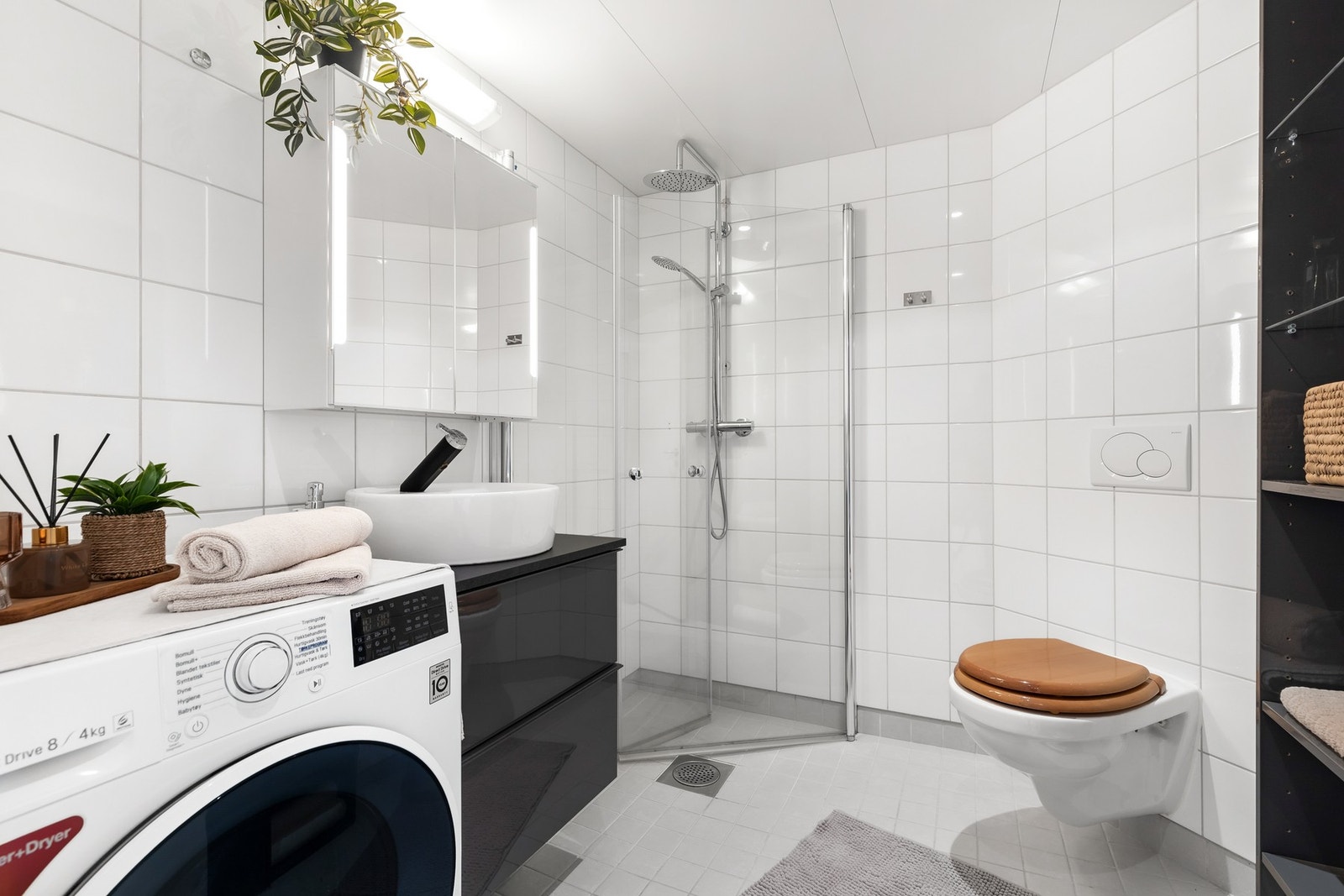 Romslig og helfliset bad med gulvvarme. Rommet er innredet med vegghengt servantinnredning og speilskap, vegghengt toalett Galleribilde