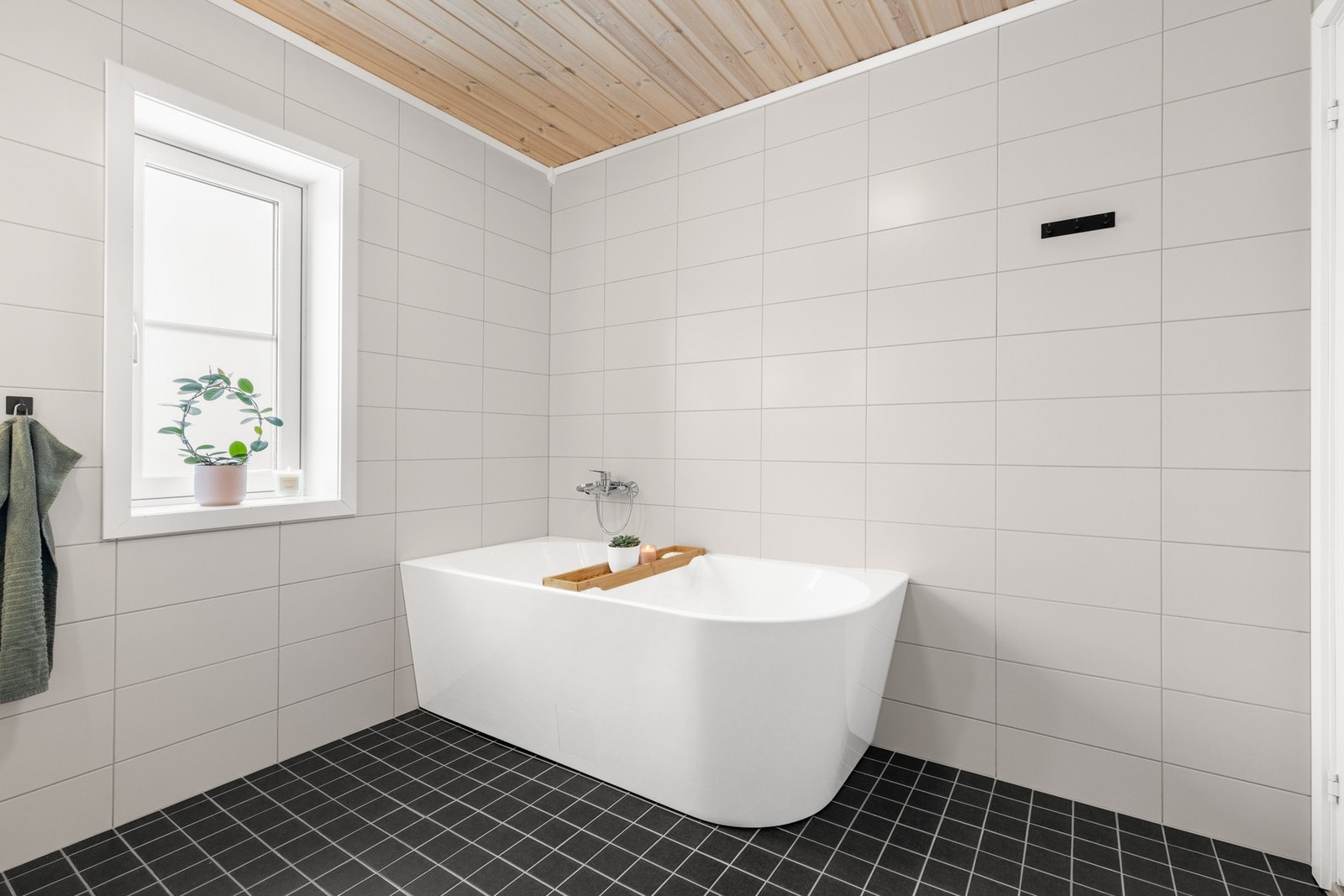 Badet er innredet med badekar, vegghengt servantinnredning og gulvstående toalett Galleribilde