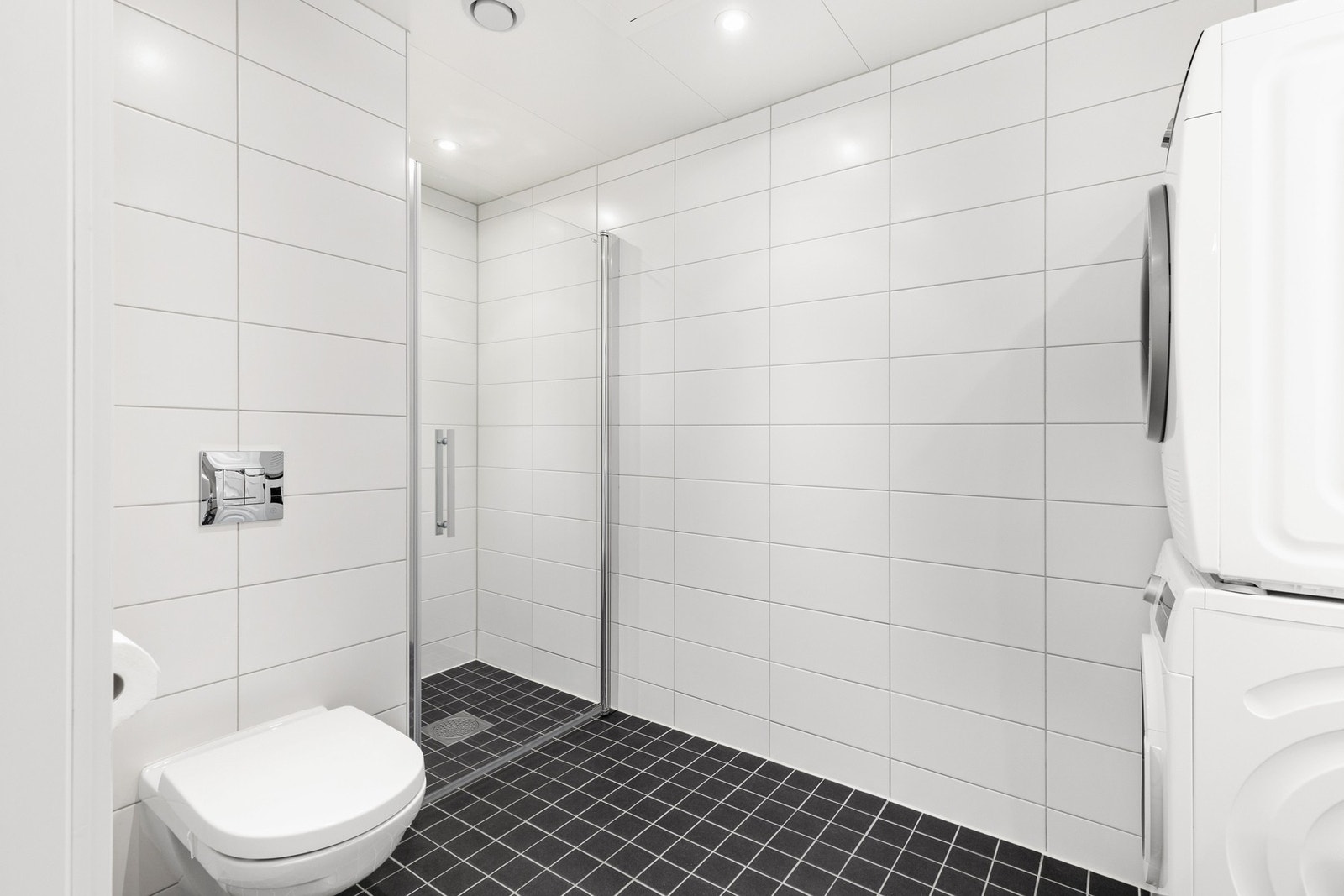 Stilrent flislagt bad med gulvvarme og downlights i tak Galleribilde