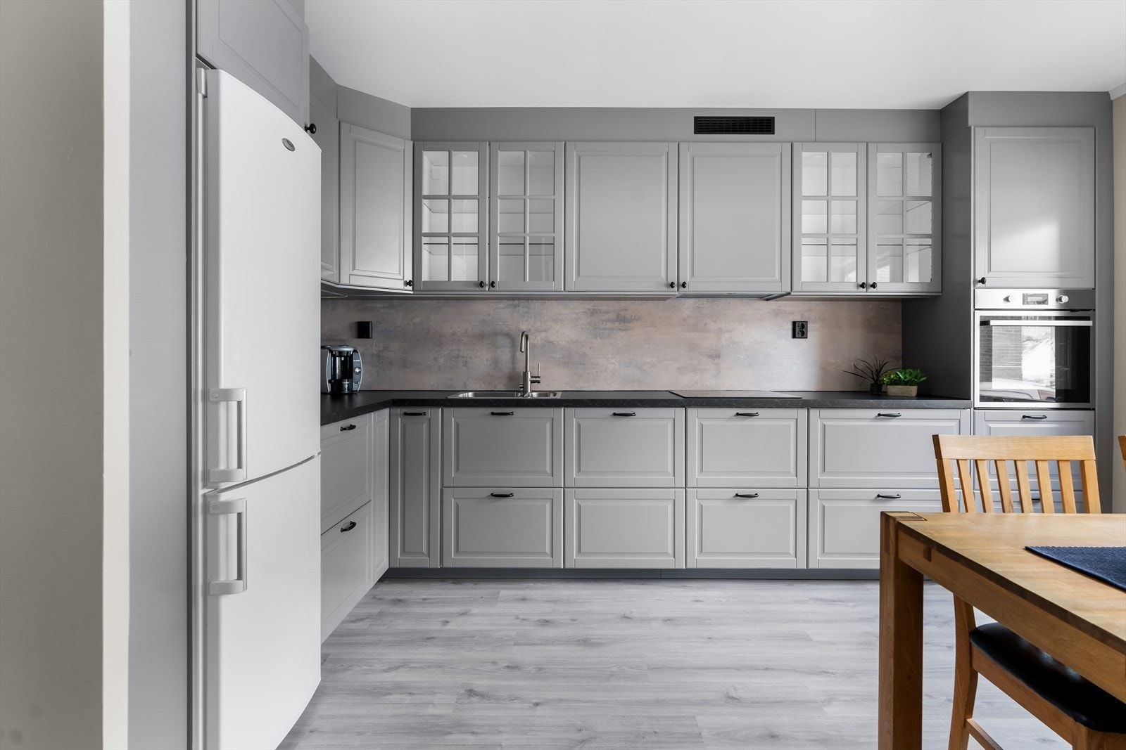 Svært pent og tidløst kjøkken fra IKEA. Kjøkkenet har grå, profilerte fronter, benkeplate i laminat og belysning under overskap. Galleribilde