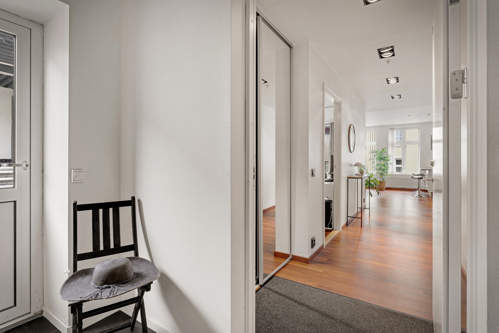 Velkommen inn! - Lys, innbydende entre med stor speil skyvedørsgarderobe Galleribilde