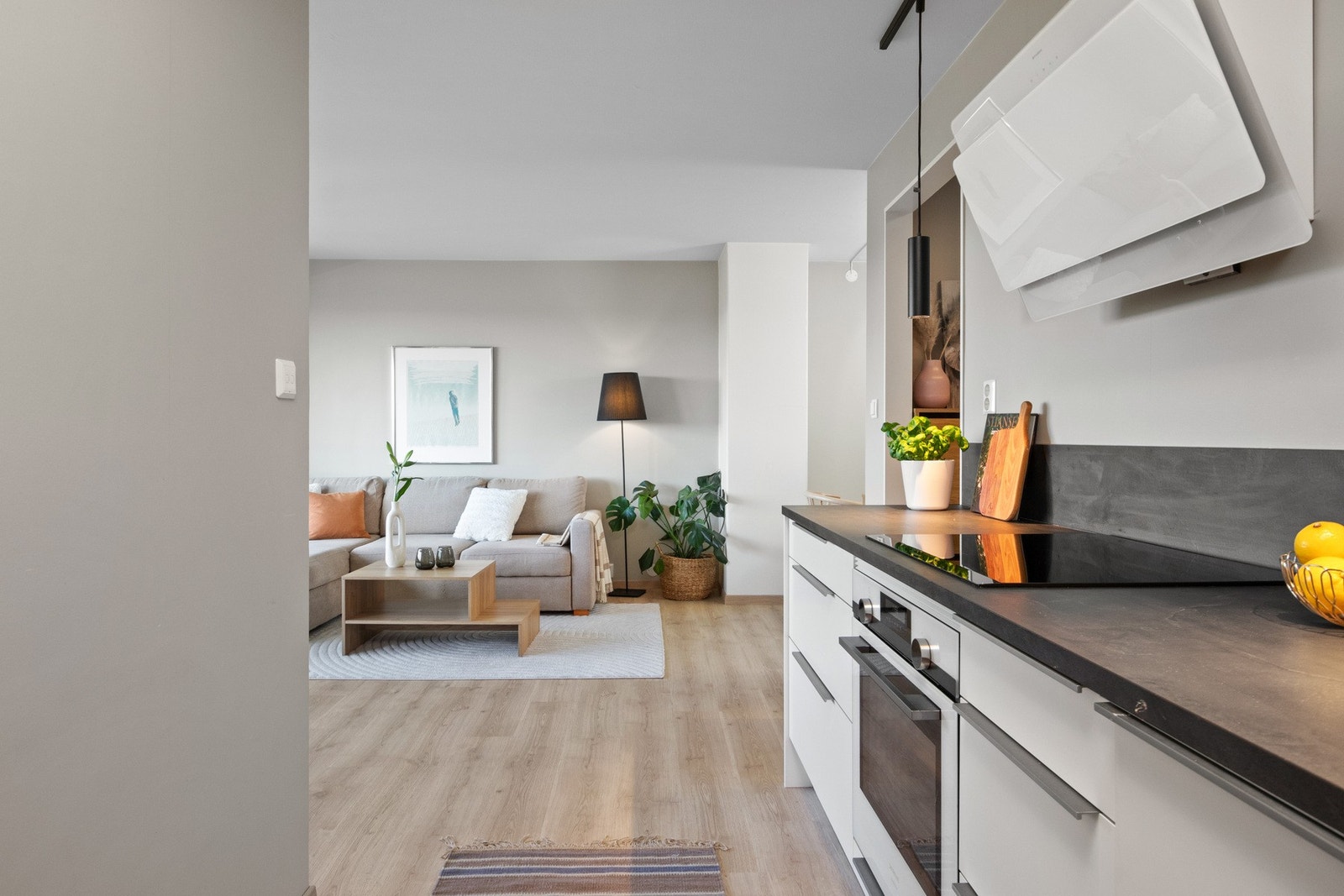 Kjøkkenet er utstyrt med integrert kjøleskap, fryseskap, oppvaskmaskin, induksjonstopp, stekeovn og en stilig kullfilterventilator med skrå front. Galleribilde