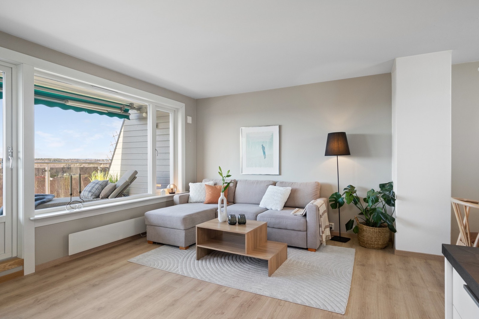 Stuen har et stilrent uttrykk med moderne eikelaminat på gulvet og listefri overgang mellom vegger og tak. Galleribilde