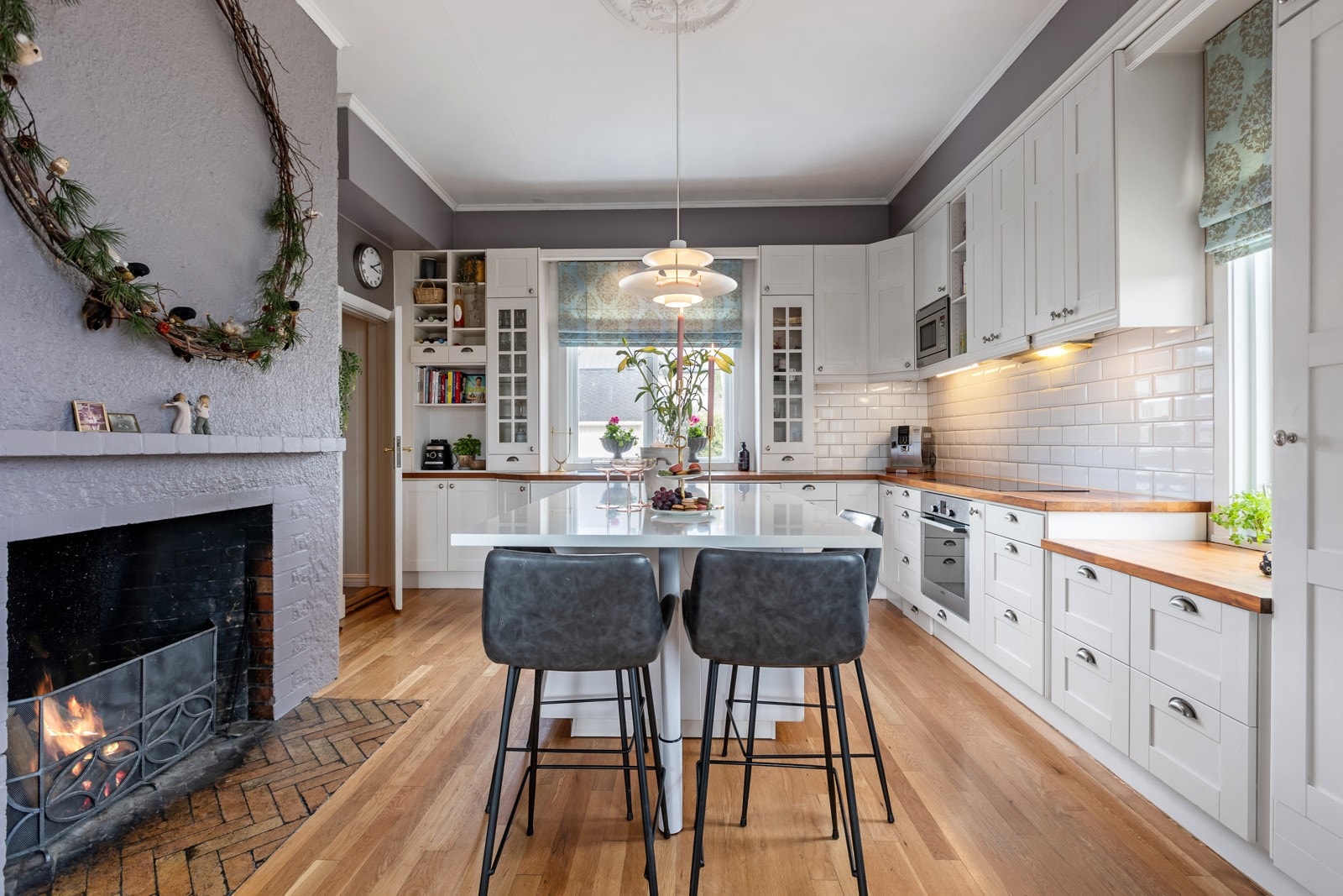 Åpen peis på kjøkkenet, som tilfører både varme og atmosfære til rommet Galleribilde