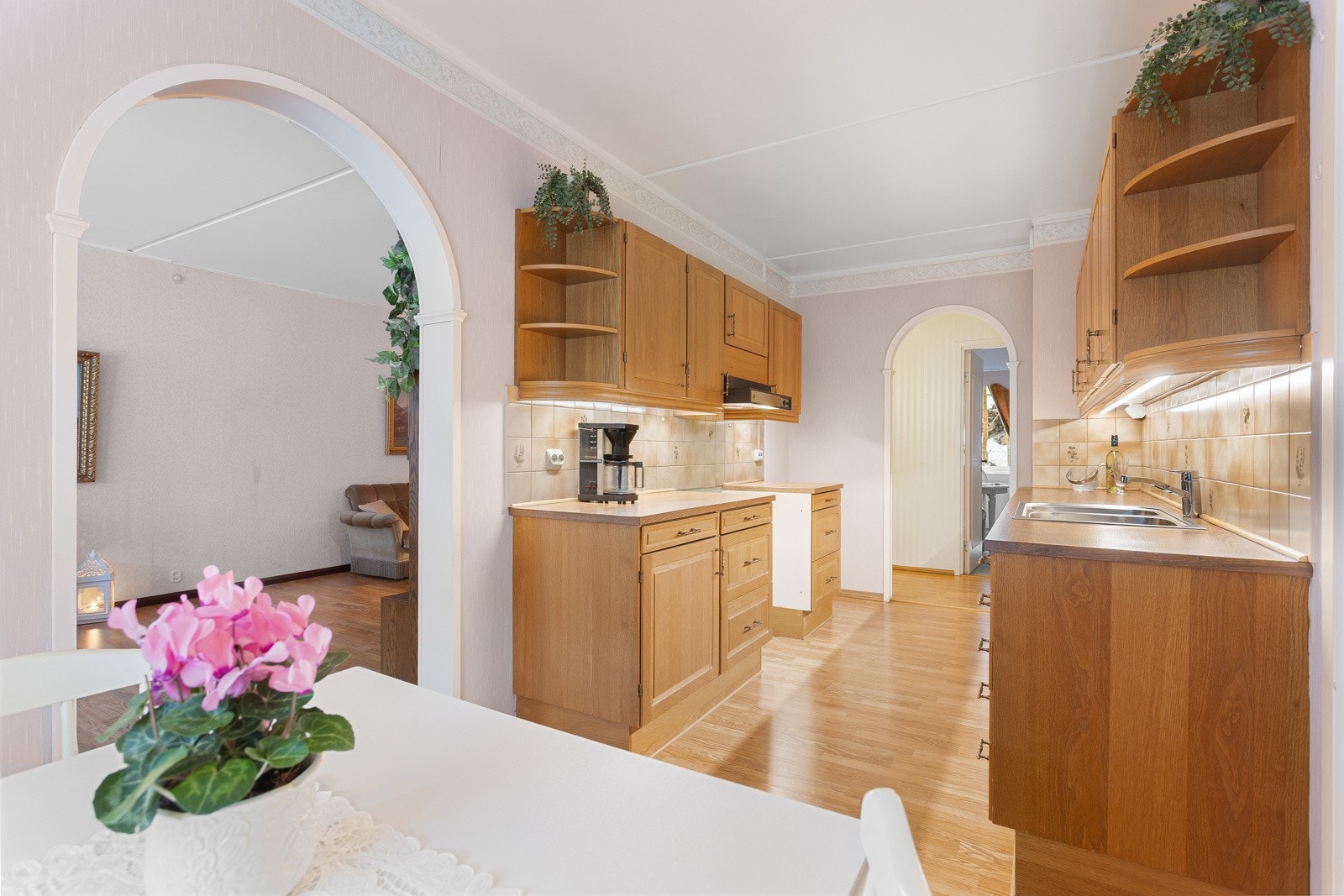 Inn på kjøkkenet finner du lyse fliser med dekorative detaljer og godt med skapplass i innredningen Galleribilde