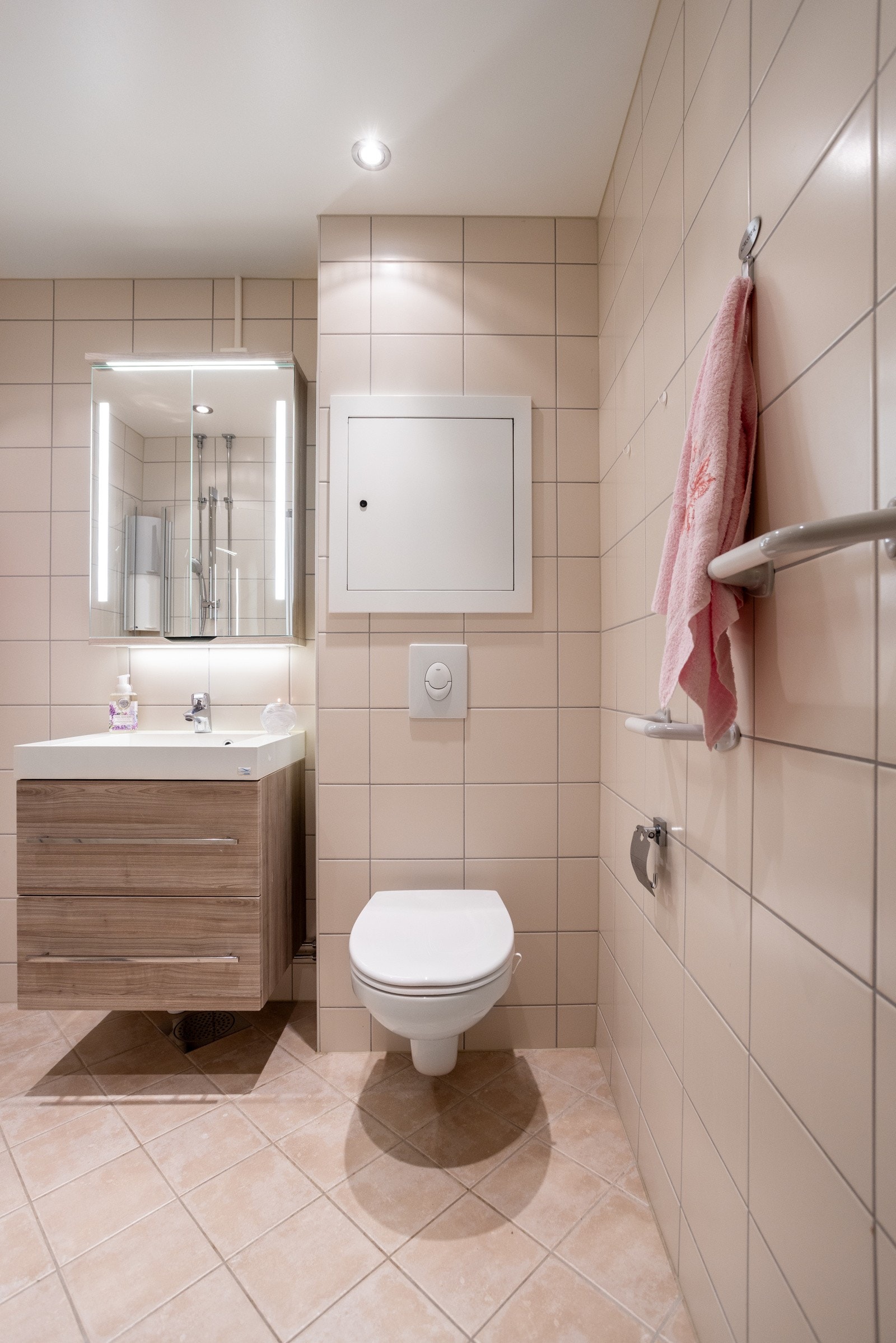 Badet ble oppusset i 2016 i regi av borettslaget og har beige fliser på gulv og vegger Galleribilde