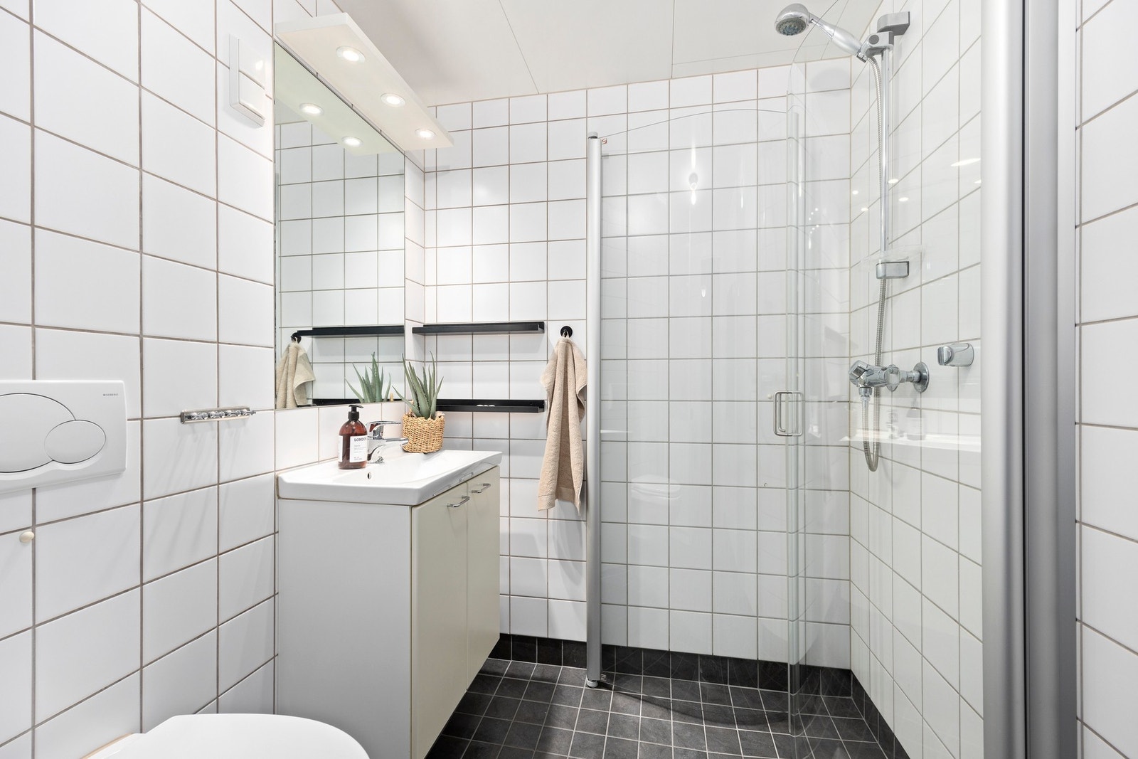 Badet har servant med underskap, speil med overlys, dusjhjørne, vegghengt wc og opplegg for vaskemaskin. Galleribilde