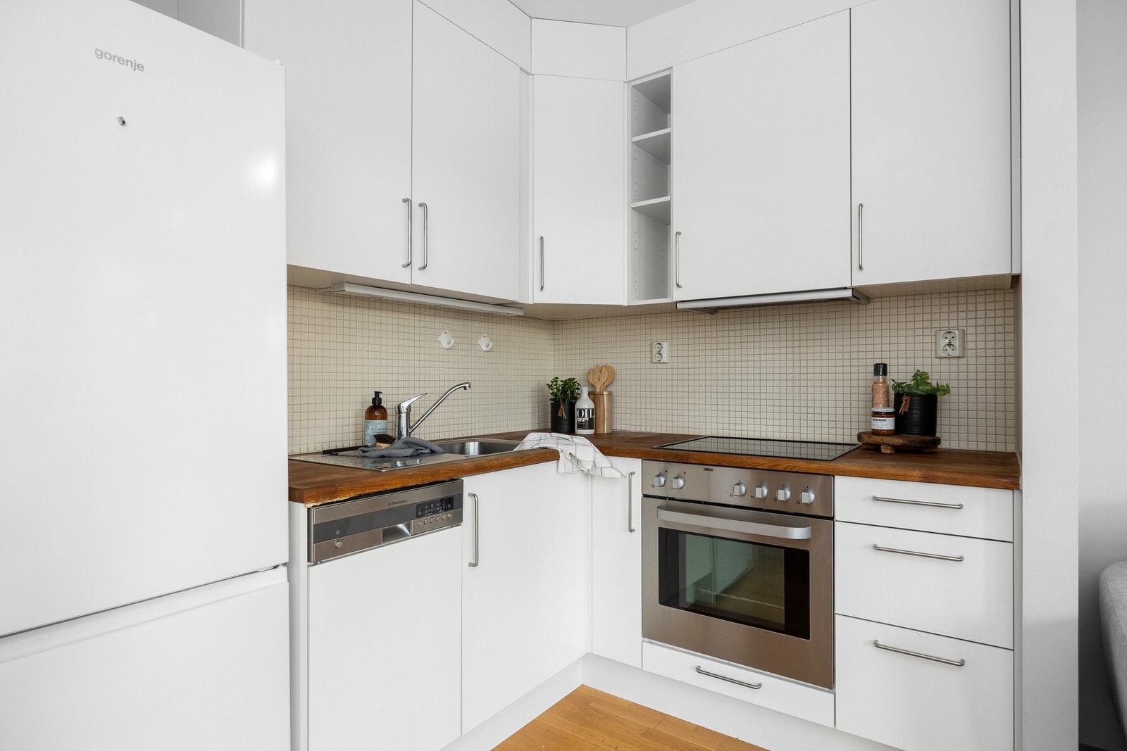 I kjøkkenet er det fliser mellom benk- og overskap, vegghengt ventilator og nedfelt oppvaskkum. Galleribilde