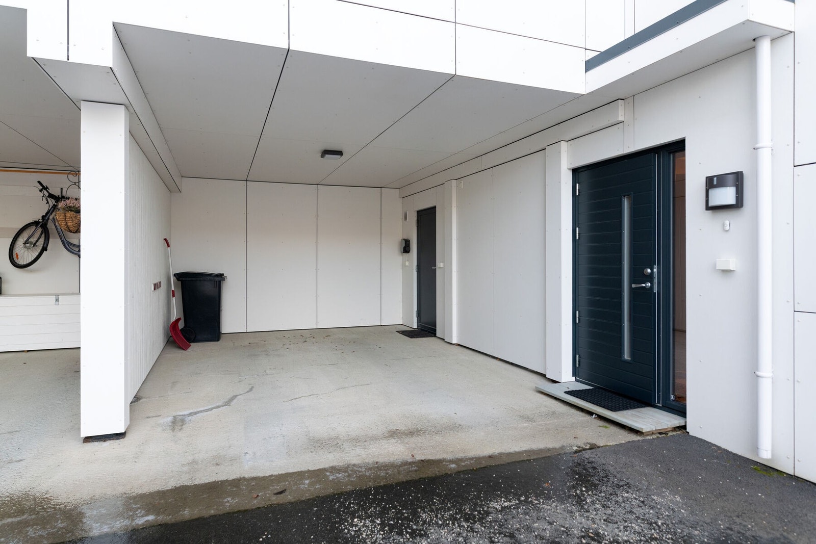 Inngangsparti og carport med elbil-lader. Inn døren til venstre er det en utebod. Galleribilde