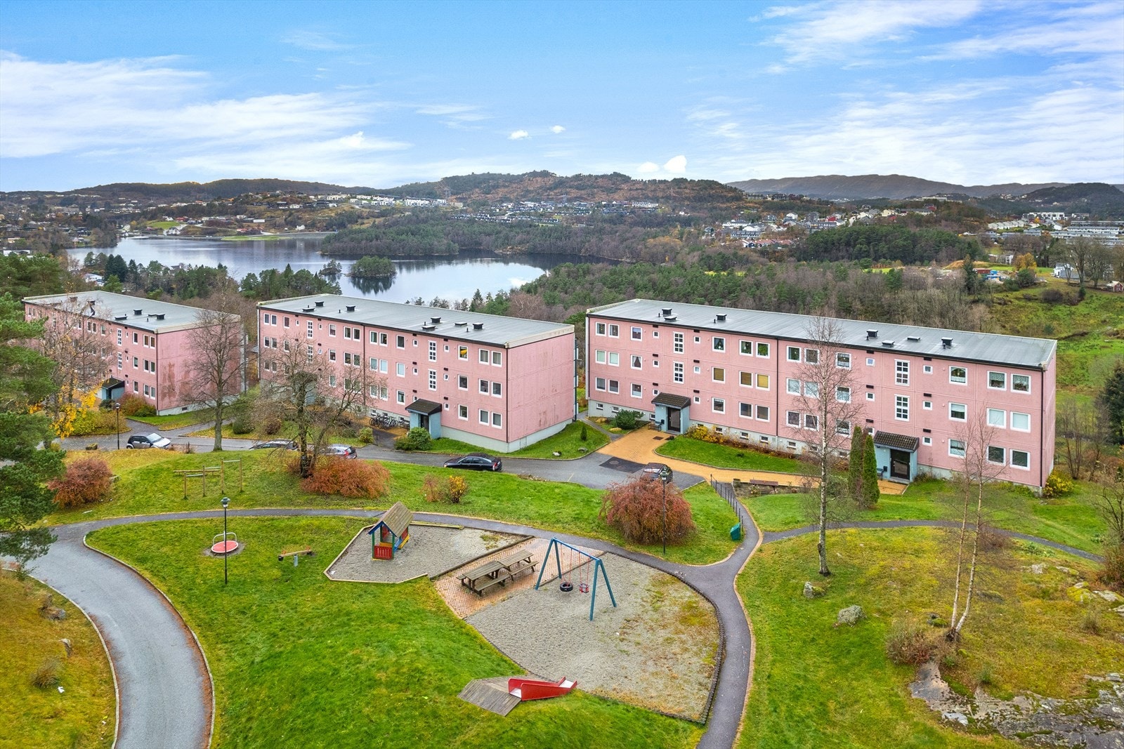 Like utenfor blokken ligger en av borettslagets lekeplasser. Fellesområdene i borettslaget er fint opparbeidet med plen, beplantning og asfalterte gangveier Galleribilde