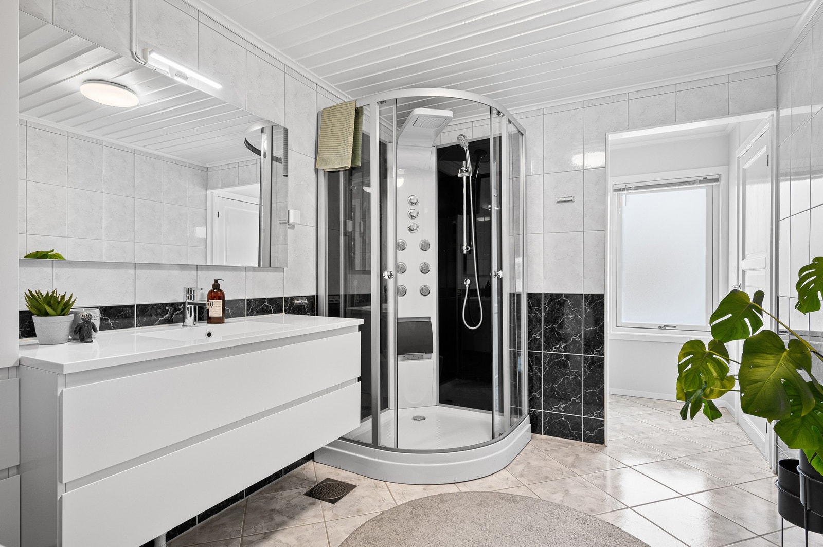 Badet er utstyrt med dusjkabinett, klosett og servant. Galleribilde