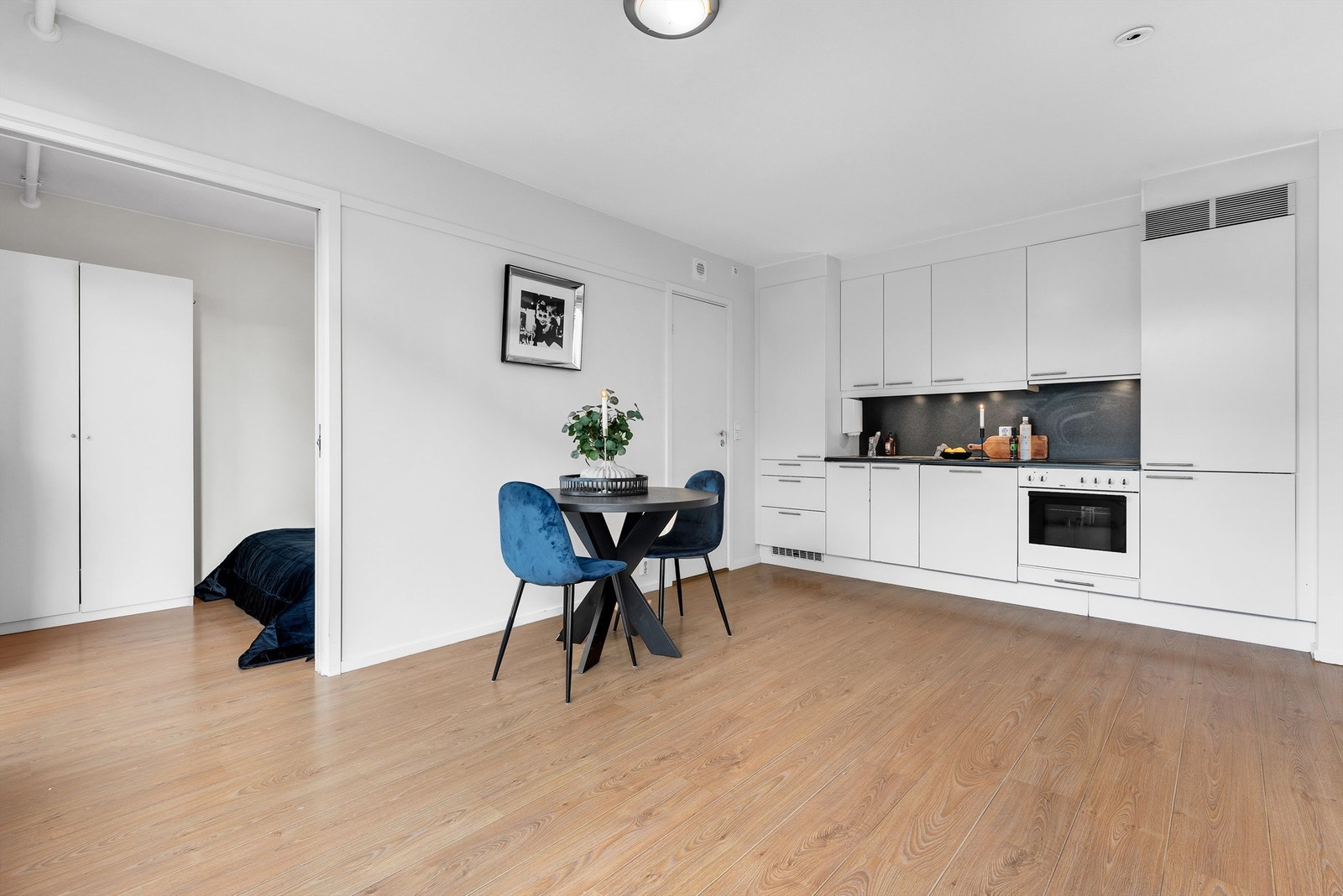 Stue med åpen kjøkkenløsning og utgang til luftebalkong samt innvendig trapp opp til den private takterrassen. Galleribilde