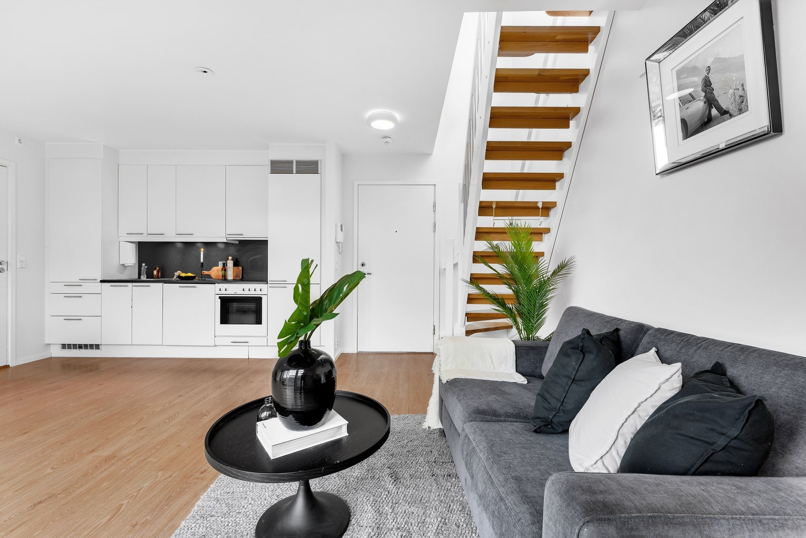 Stue med åpen kjøkkenløsning og utgang til luftebalkong samt innvendig trapp opp til den private takterrassen. Galleribilde