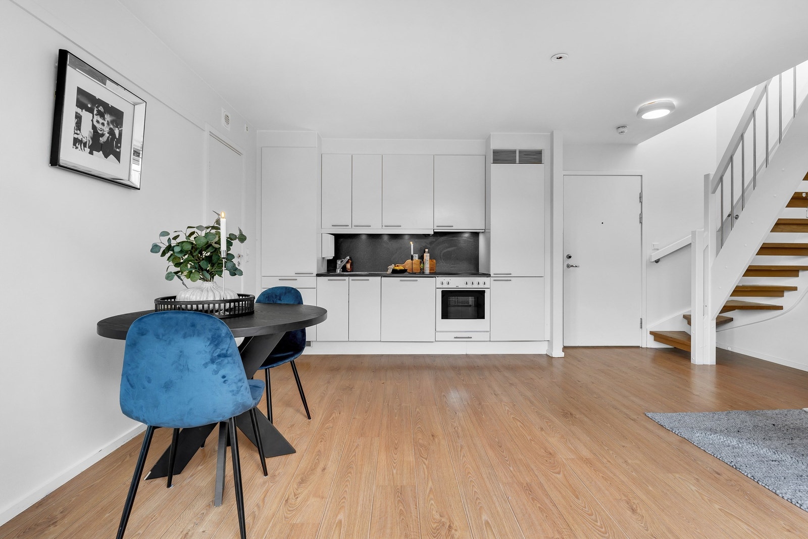 Stue med åpen kjøkkenløsning og utgang til luftebalkong samt innvendig trapp opp til den private takterrassen. Galleribilde