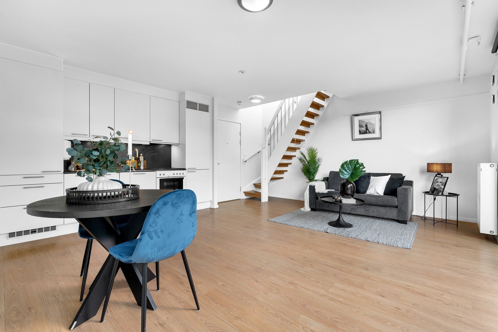 Stue med åpen kjøkkenløsning og utgang til luftebalkong samt innvendig trapp opp til den private takterrassen. Galleribilde