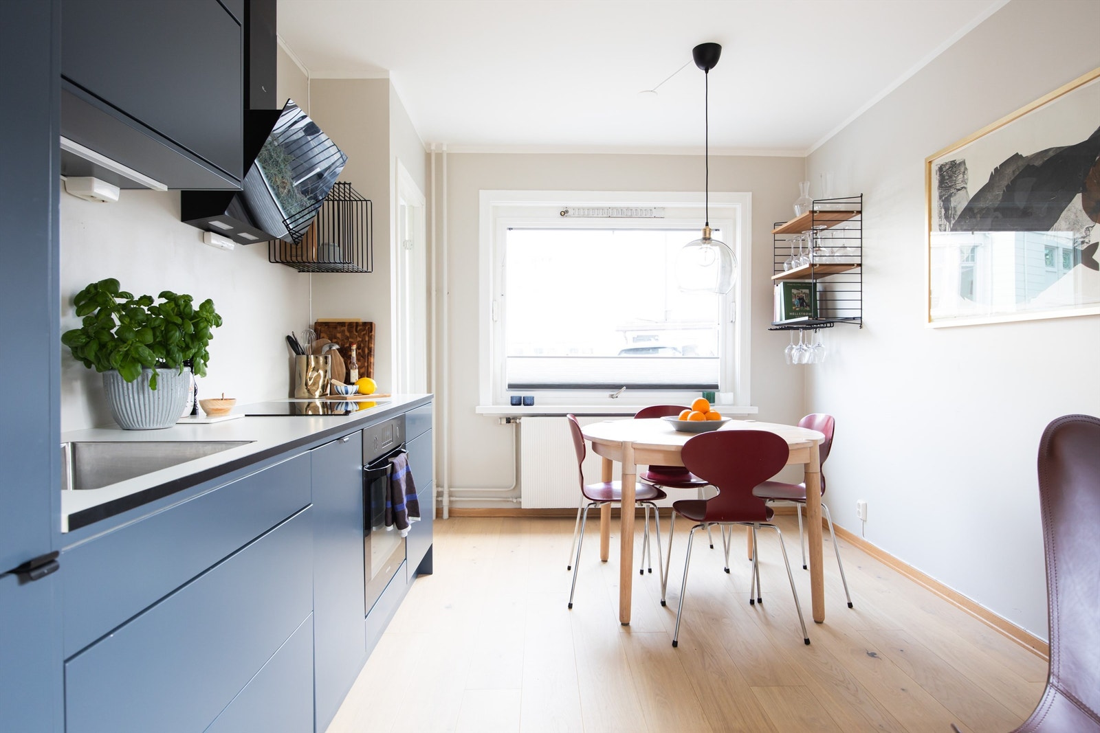 Den åpne løsningen mot kjøkkenet gjør det enkelt å tilpasse møbleringen etter dine behov, og skaper en sømløs overgang mellom stue og kjøkken. Galleribilde