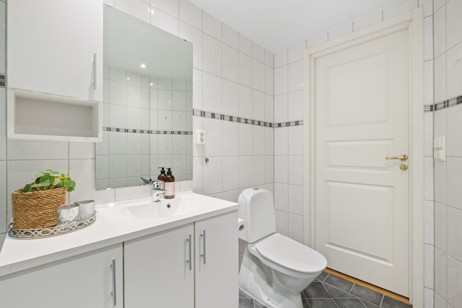 Helstøpt servantinnredning med speil på vegg. Lys fra innfelte spotter i tak. Galleribilde