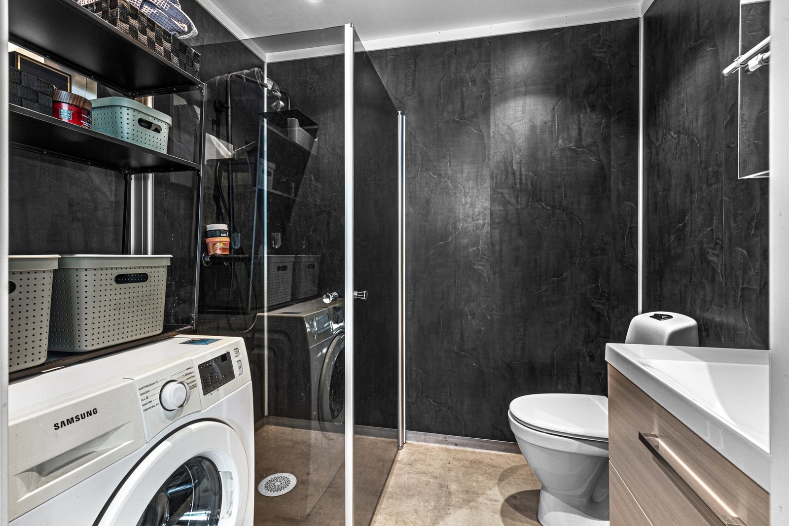 Badet i enheten er romslig og innredet med dusjhjørne, toalett, servant med innredning og opplegg fir oppvaskmaskin. Galleribilde
